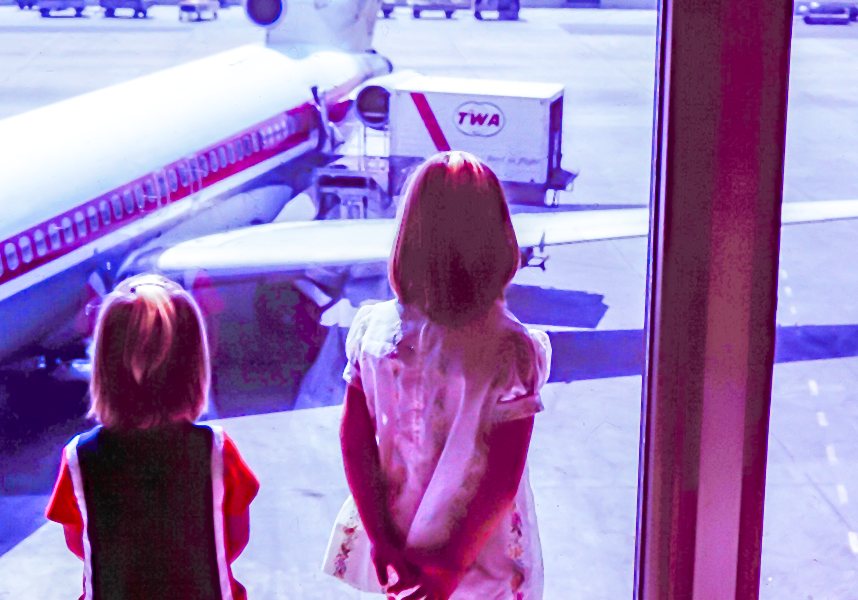 2 girls watching an airplane at LAX airport gate dreaming of Someday